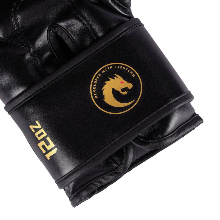 Macro of underside wrist strap: gold “12 oz” weight stamp and round “Developed With Fighters” dragon crest on satin-finish black leather.