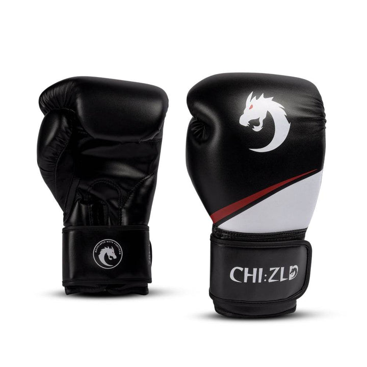 Pair of black/white chizld boxing gloves, one palm-side and one knuckle-side; matte white/red dragon emblem and swoosh accent on striking surface, CHIZLD logo on wrist straps.