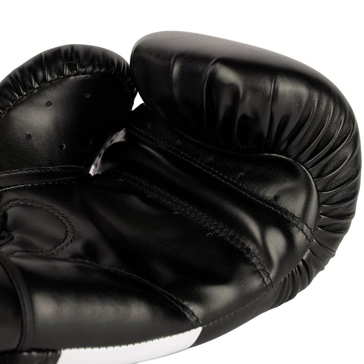 Interior palm shot displaying curved grip bar, perforations for airflow, and dense ergonomic padding along thumb seam.