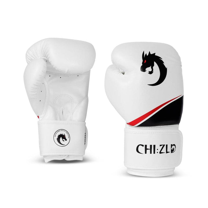 Pair of white chizld boxing gloves, one palm-side and one knuckle-side; matte gold dragon emblem and swoosh accent on striking surface, CHIZLD logo on wrist straps.