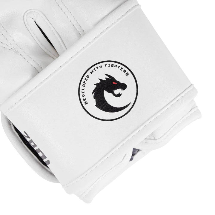Macro of underside wrist strap: black “12 oz” weight stamp and round “Developed With Fighters” dragon crest on satin-finish white leather.