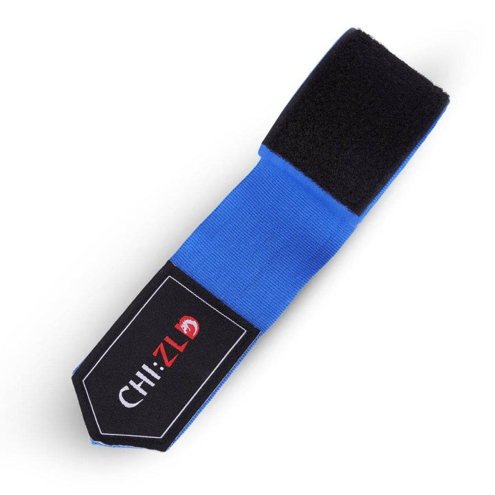 Closeup of partially unrolled wrap; black hook-and-loop closure sewn to vivid blue stretch fabric, CHIZLD logo patch at tapered end.