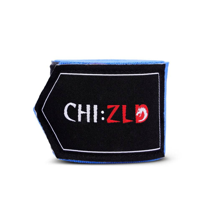 Folded patch detail: black rectangle with white outline, white “CHI:” text and red “ZLD” plus small red dragon emblem, edged in blue stitching.