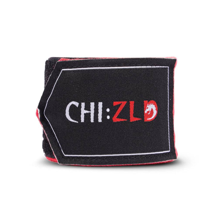 Upright roll with visible logo patch wrapped around core of bright red handwrap.