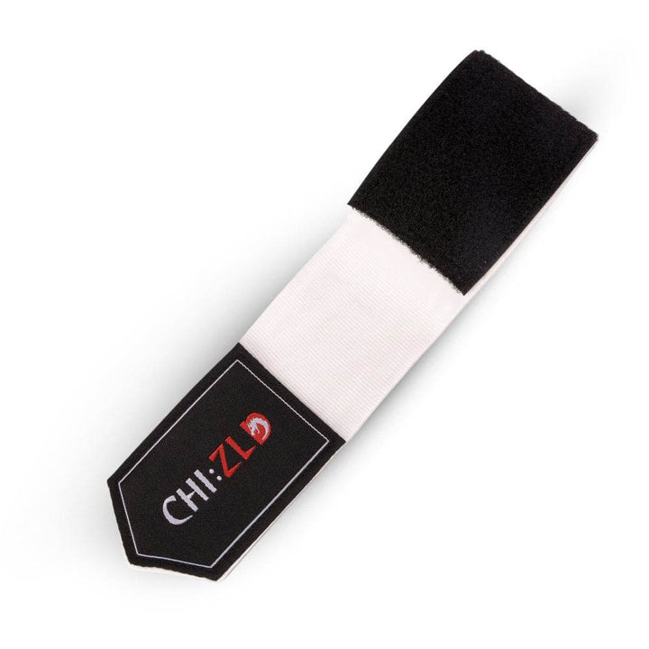 Closeup of partially unrolled wrap; black hook-and-loop closure sewn to white stretch fabric, CHIZLD logo patch at tapered end.