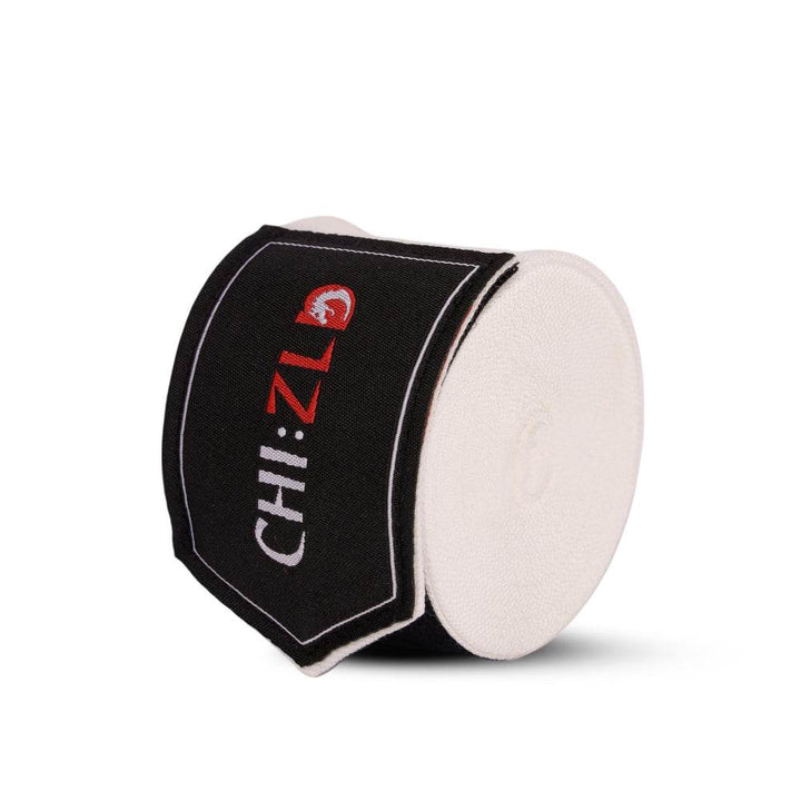 Upright roll wrapped with black logo patch, highlighting circular layers of tightly wound white fabric.