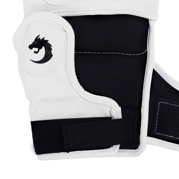 Macro of thumb-side padding and Velcro tab, emphasizing raised white dragon icon on smooth black surface.