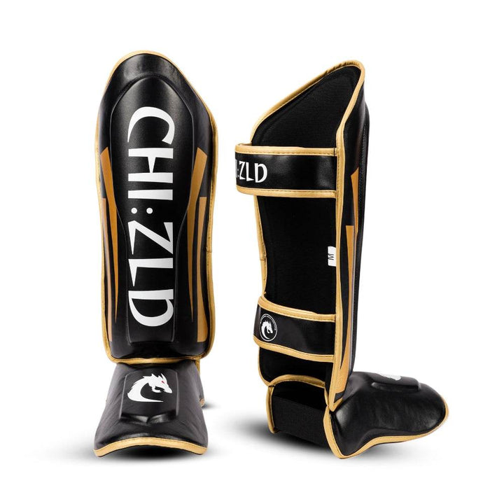 One guard front-facing beside rear view of the other, showing twin hook-and-loop straps with “CHIZLD” text and open-calf design.