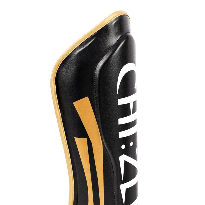 Detail of contoured knee-cut top edge with reinforced padding and gold piping trim.