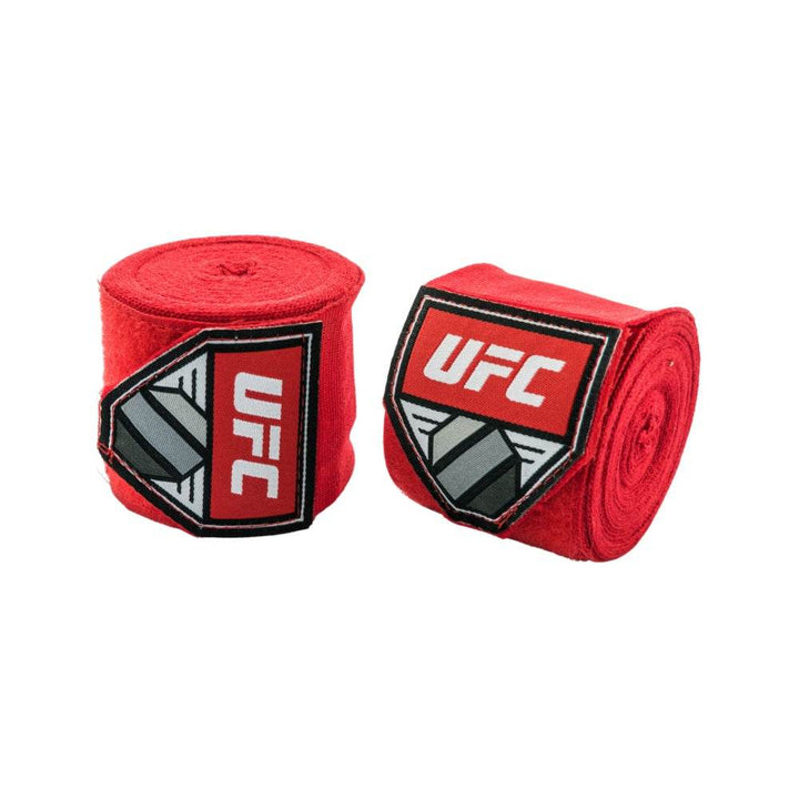 Two solid-red UFC hand-wrap rolls positioned side-by-side; each features the classic red-and-white UFC shield patch.