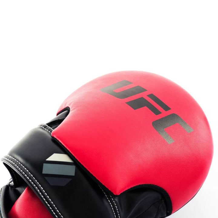 Red hood close-up – Texture and sheen of red top panel with “UFC” lettering and contrasting black leather below.