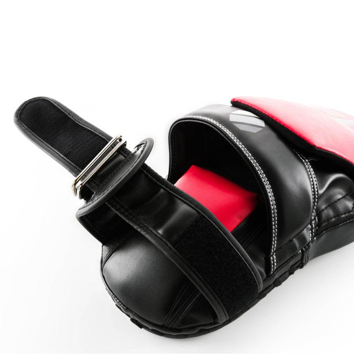 Strap & hand tunnel – Open mitt revealing padded palm dome, white top-stitching and wide black hook-and-loop strap threaded through metal D-ring for closure.