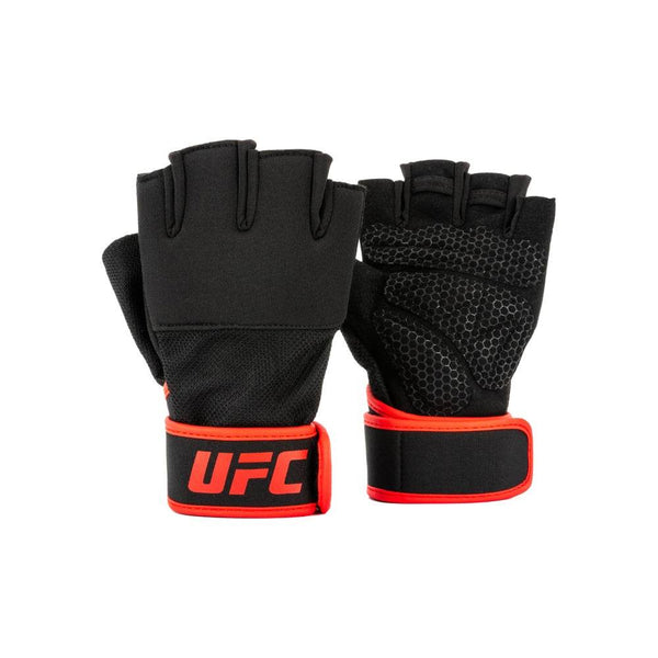 Pair view – front & palm: Two UFC half-finger weight-lifting gloves displayed side-by-side: left glove shows smooth black knuckle side; right glove shows palm side with black hex-pattern grip padding. Both feature wide black wrist straps edged in bright red and a bold red “UFC” logo.