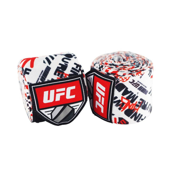 Pair of rolled UFC 4.5 m hand wraps in a white base with scattered black and red graffiti-style UFC lettering; each roll displays the red UFC shield patch.