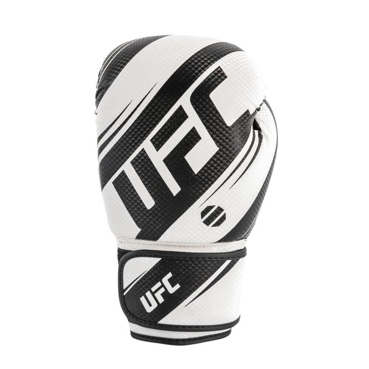 Front view of a white-and-black UFC Performance Rush boxing glove standing upright, featuring a smooth white striking surface with curved black diagonal stripes, black thumb covering, and a wide black hook-and-loop wrist strap.