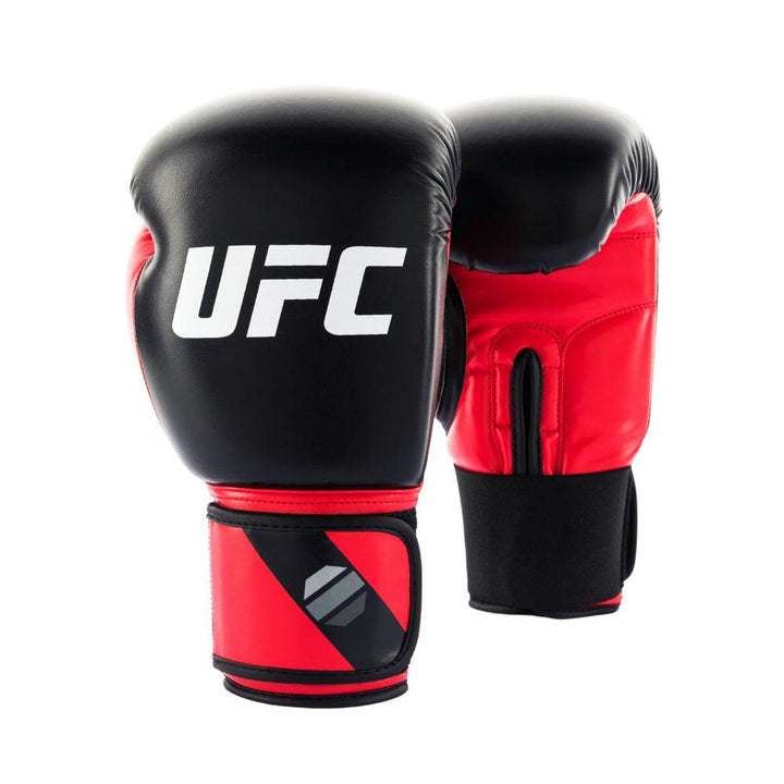 Front view of a red-and-black UFC Pro Compact bag glove, featuring a glossy black knuckle panel with bold red “UFC” lettering, red padded wrist cuff, and a ventilated black palm section designed for secure bag training.