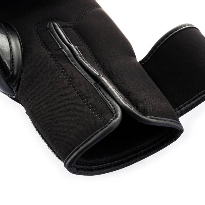 Detail view of the open wrist-wrap cuff, showing reinforced piping and sturdy black hook-and-loop fastening panel.