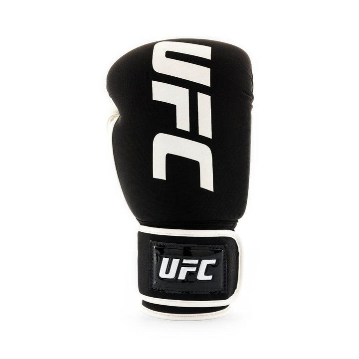Straight front view of a single black UFC fitness glove with bold white vertical “UFC” lettering and a black hook-and-loop wrist strap.