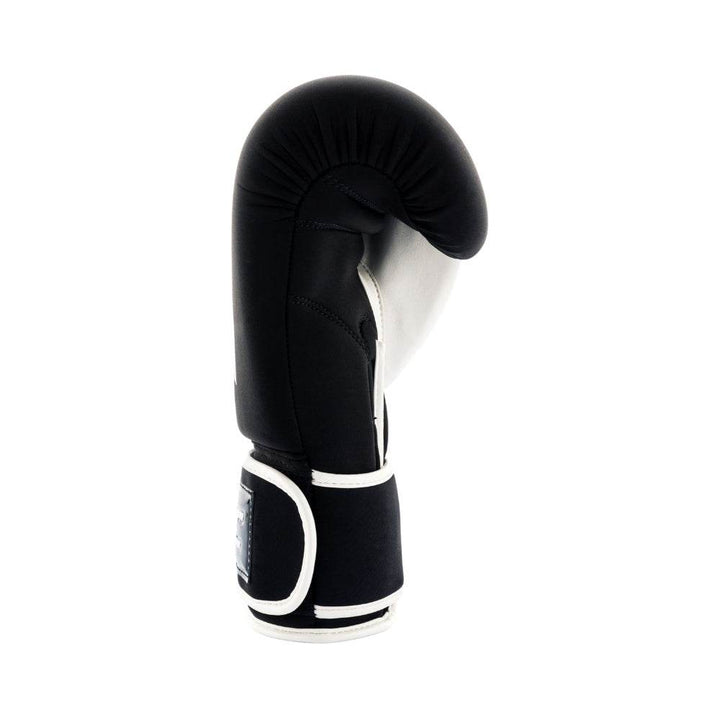 Right-side profile of the glove revealing layered knuckle padding, curved strike surface and the seam between black shell and white palm.