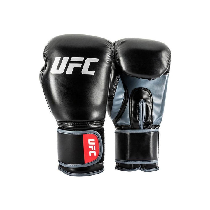 Front three-quarter view of a pair of UFC Stand Up training gloves: lead glove faces forward with white “UFC” wordmark, rear glove shows grey-blue palm panel, black thumb and hook-and-loop wrist strap.