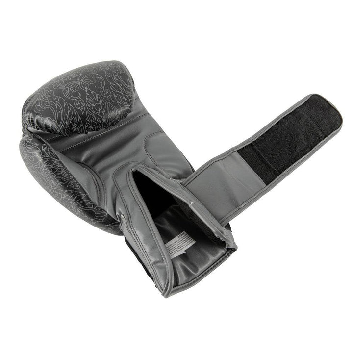 Palm-side view of the black UFC Thai Naga boxing glove with the hook-and-loop wrist strap fully opened, revealing the breathable mesh palm panel, padded thumb channel, and interior lining beneath the knuckle area decorated with a red serpent-scale graphic.