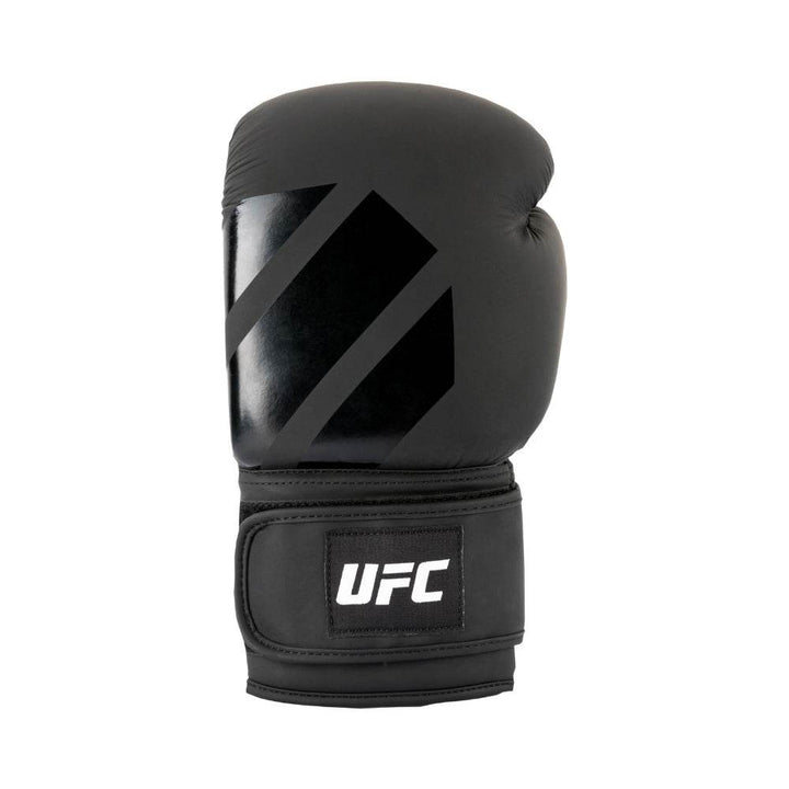Single glove upright, subtle tonal “slash” logo across curved striking surface, dense foam bulge at first knuckles.
