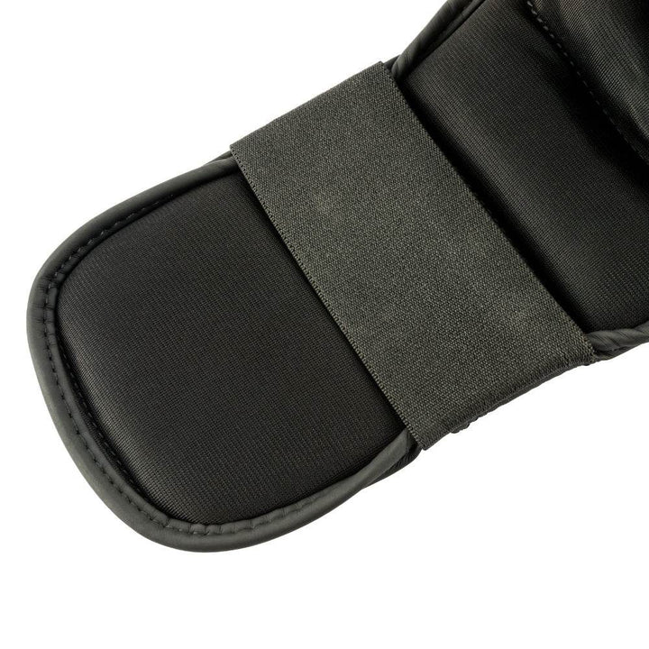 Close-up – foot strap: Detail of the elastic hook-and-loop strap anchoring the instep pad under the foot.