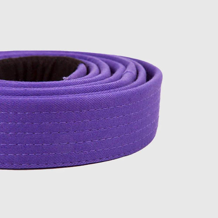 Side view of a rolled Venum Brazilian Jiu-Jitsu purple belt with visible black patch and reinforced stitching.