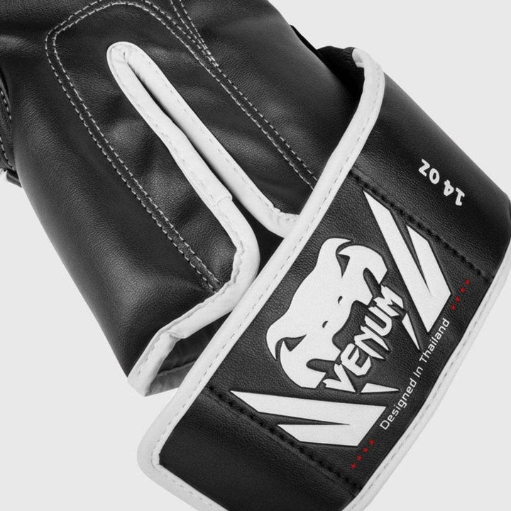 Close-up of the wrist wrap showing the bold white Venum logo, “Designed in Thailand” text, and layered black-and-white leather construction.