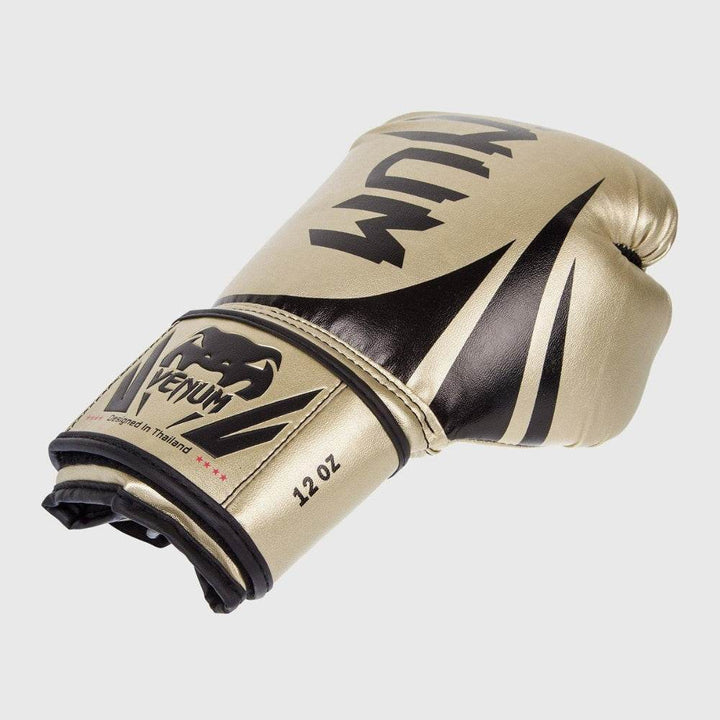 Angled view of the glove showing the full outer surface with bold black graphic stripes, Venum branding, and Velcro strap design.