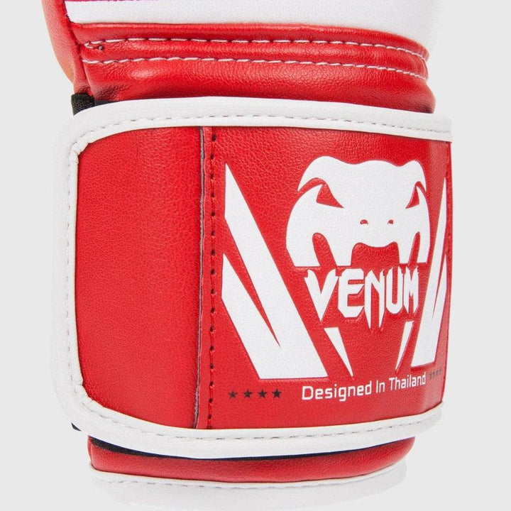 Macro view of the wrist strap with white snakehead logo and directional chevron graphic in white contrasting against red leather.