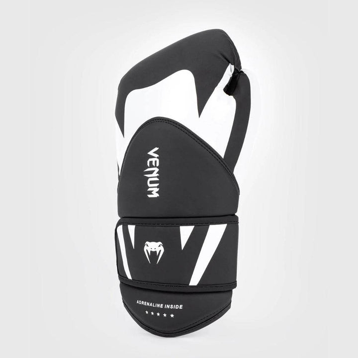 Angled shot of a single black and white Venum Challenger 4.0 glove, highlighting the modern contour and fang-style wrist design.