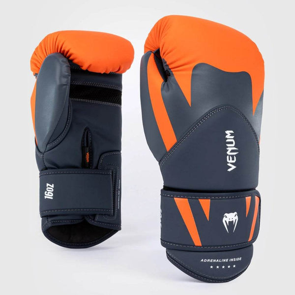 A pair of Venum Challenger 4.0 boxing gloves in matte grey with striking orange accents, featuring the Venum logo and the phrase “Adrenaline Inside” on the wrist strap.