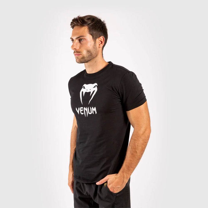 Side view of the man in theVenum Classic black t-shirt and black shorts.