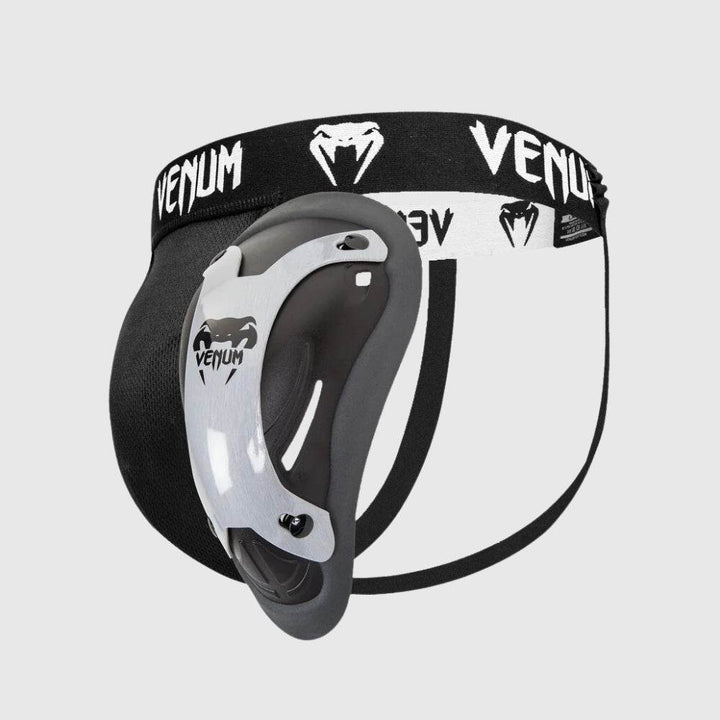Venum Elite groinguard with metallic silver cup and black jockstrap, branded waistband.