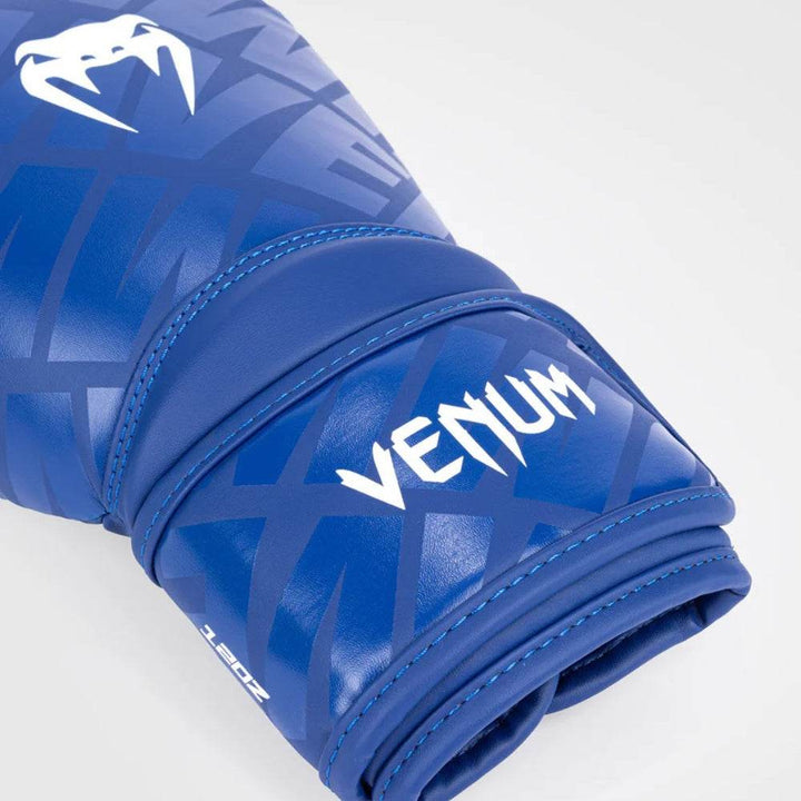 Close-up of the wrist strap on the blue/white glove featuring black “VENUM” branding and structured padding.