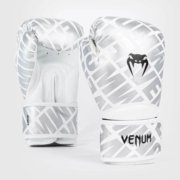 Front and back view of Venum Contender 1.5XT boxing gloves in a striking white and silver design, featuring a black Venum snakehead logo and an all-over diagonal VENUM text pattern.