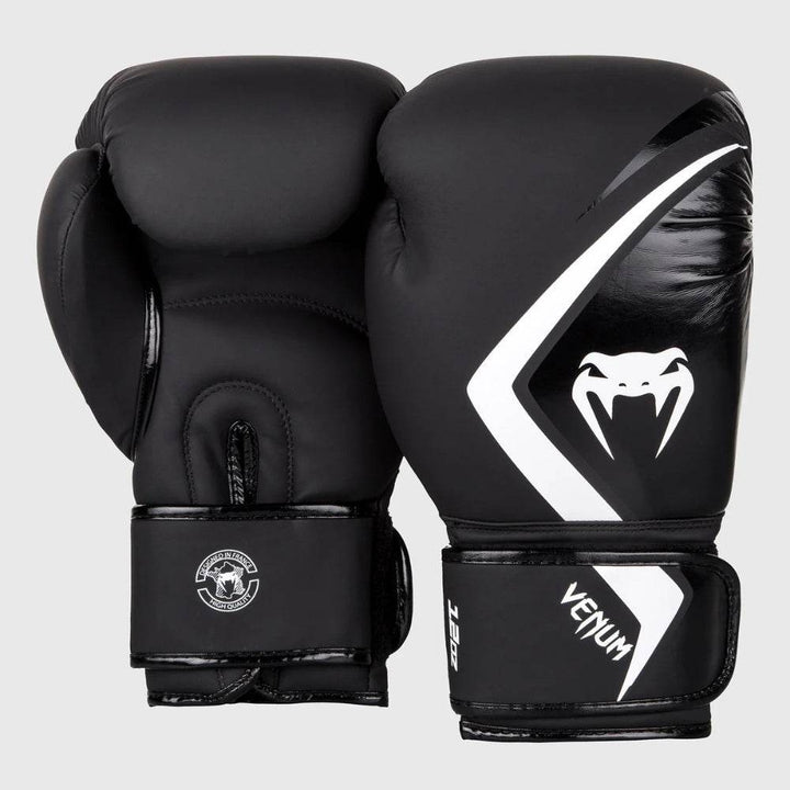 Front and back view of Venum Contender 2.0 boxing gloves in matte black with a bold white Venum snakehead logo and diagonal graphic stripe on the striking surface.