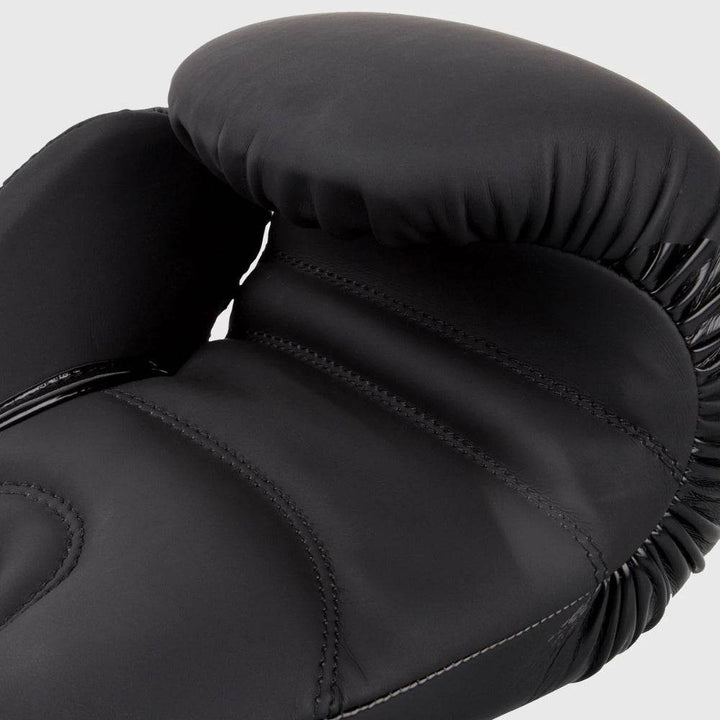 Detailed view of the palm side of the glove, showcasing curved stitching, dense padding, and elastic cinching along the wrist and finger arch.