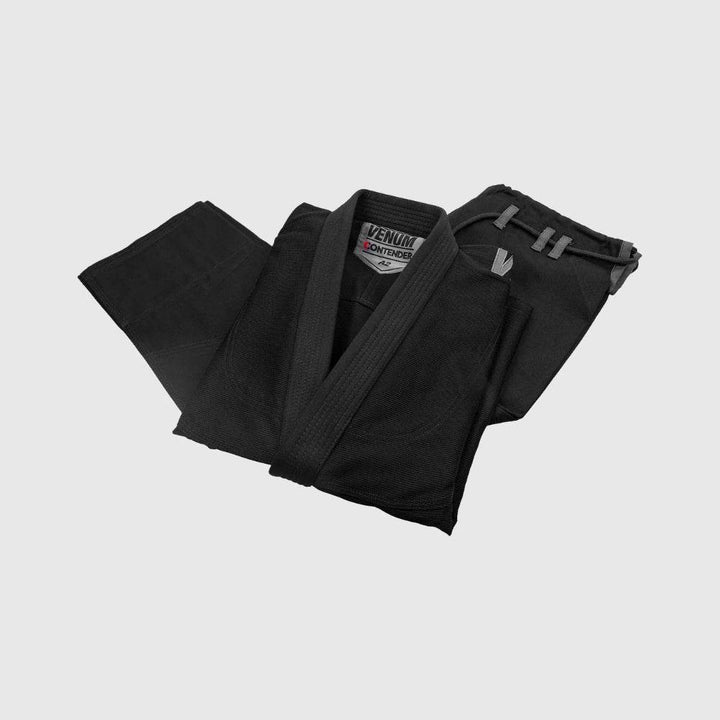 Venum Contender Evo BJJ Gi jacket and pants neatly folded side-by-side in black, highlighting the thick fabric and construction details.