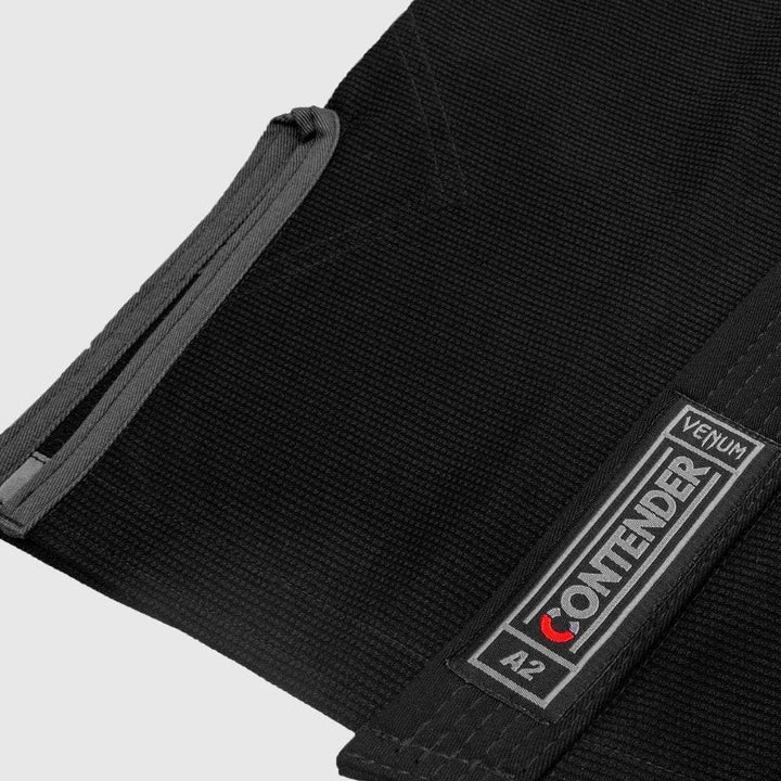 Detailed shot of the lower front of the gi jacket showing the stitched 'Venum Contender A2' label and clean seam work.