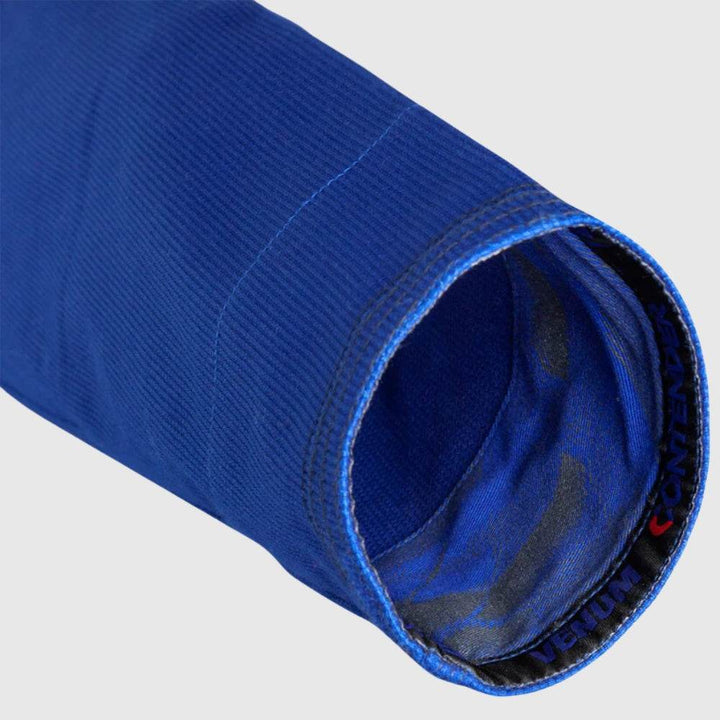 Sleeve cuff detail of the blue gi with visible reinforced stitching and black printed VENUM CONTENDER inner trim.