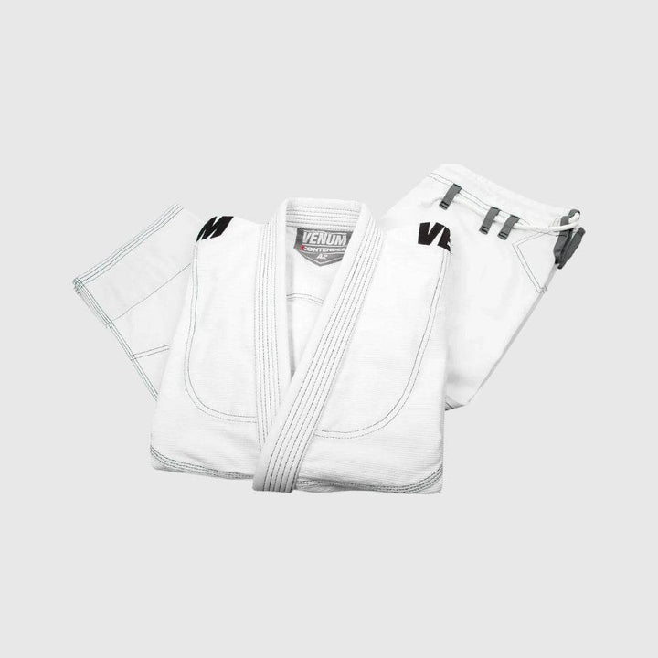 White jacket and pants folded together neatly, showcasing collar tag and drawstring loops.