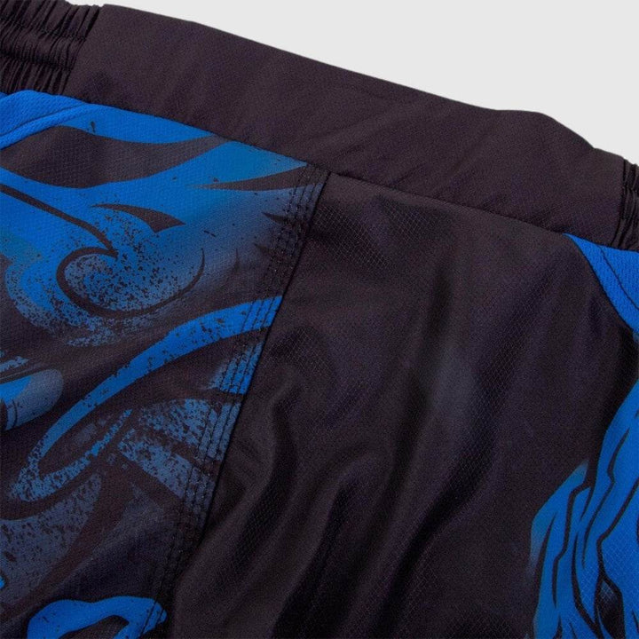 Close-up of side seam on black and blue panel of shorts showing continuation of Oni graphic and fine-textured synthetic fabric material.
