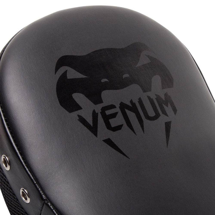 Close-up of the Venum snakehead logo printed in black on the front padded surface of the mitt.