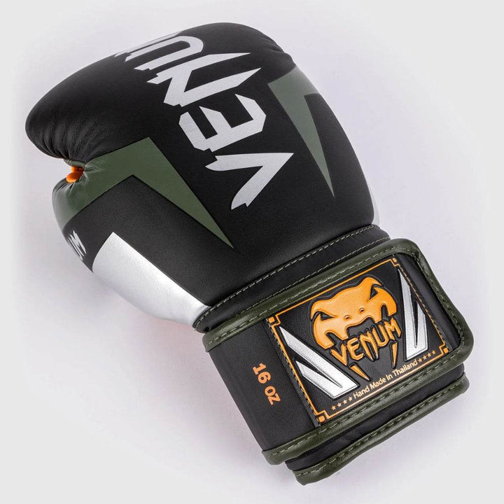 Close-up of a Venum Elite boxing glove lying on its side, revealing the Venum logo and reinforced striking surface in black and silver.