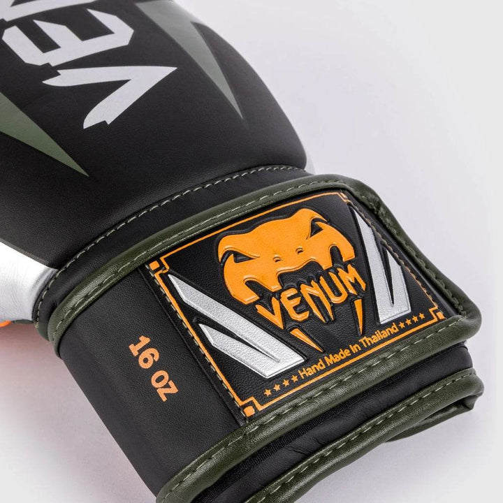 Detailed close-up of the Venum logo patch on the wrist strap, with black, orange, and silver colors and "Hand Made in Thailand" text.