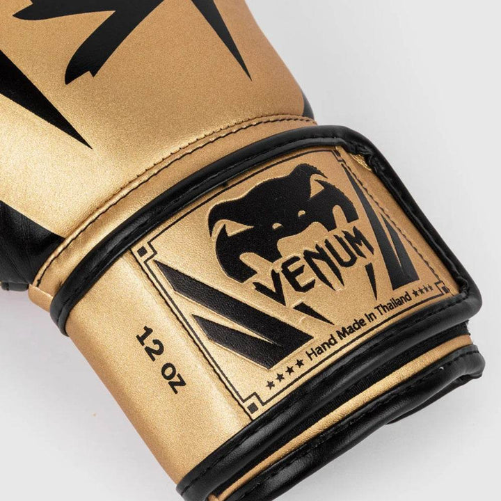 Detailed wrist view showing the Venum patch in gold and black, complete with stitching, stars, and “12 OZ” size marking.