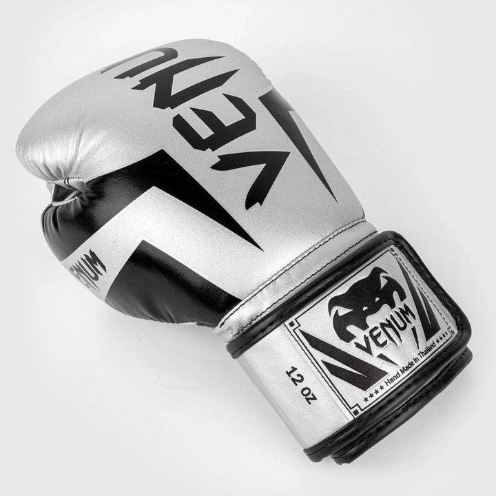 Top-down angled view of a Venum Elite boxing glove showing the curved fist shape, wrist strap branding, and contrast stitching.