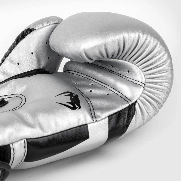 View of the palm side of the glove, featuring ventilation holes, contoured grip, and sleek silver leather with black detailing.